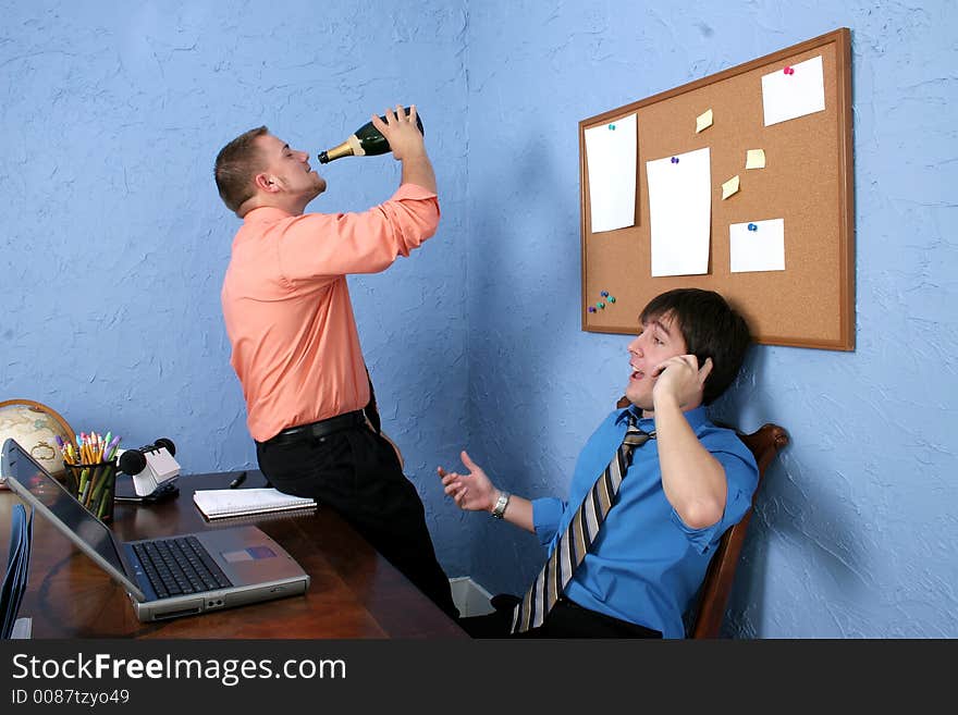 Two male workers drinking and goofing off on the job. Two male workers drinking and goofing off on the job