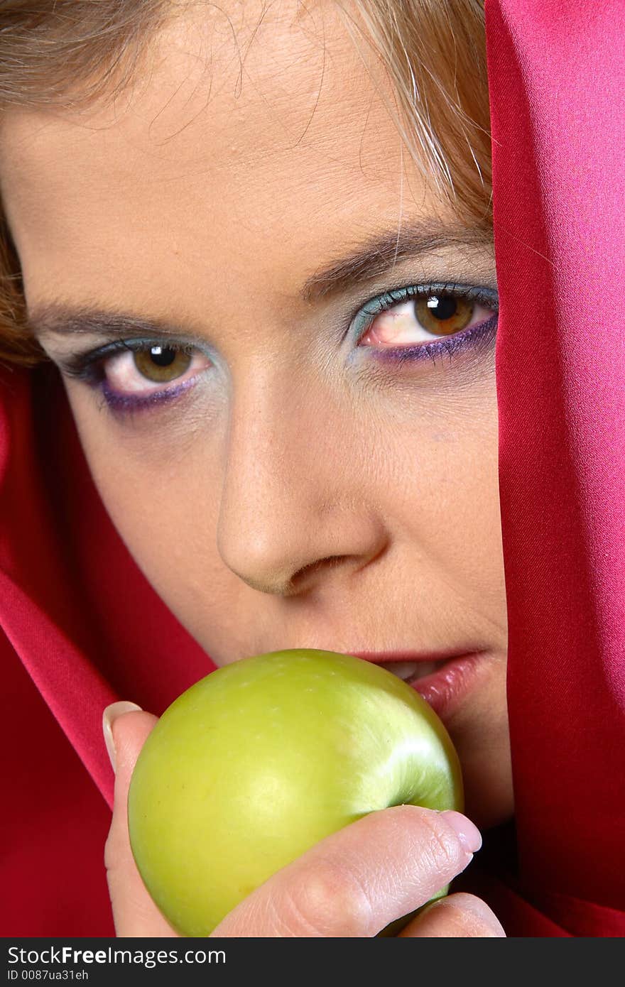 Blond woman in red scarf eating an apple. Blond woman in red scarf eating an apple