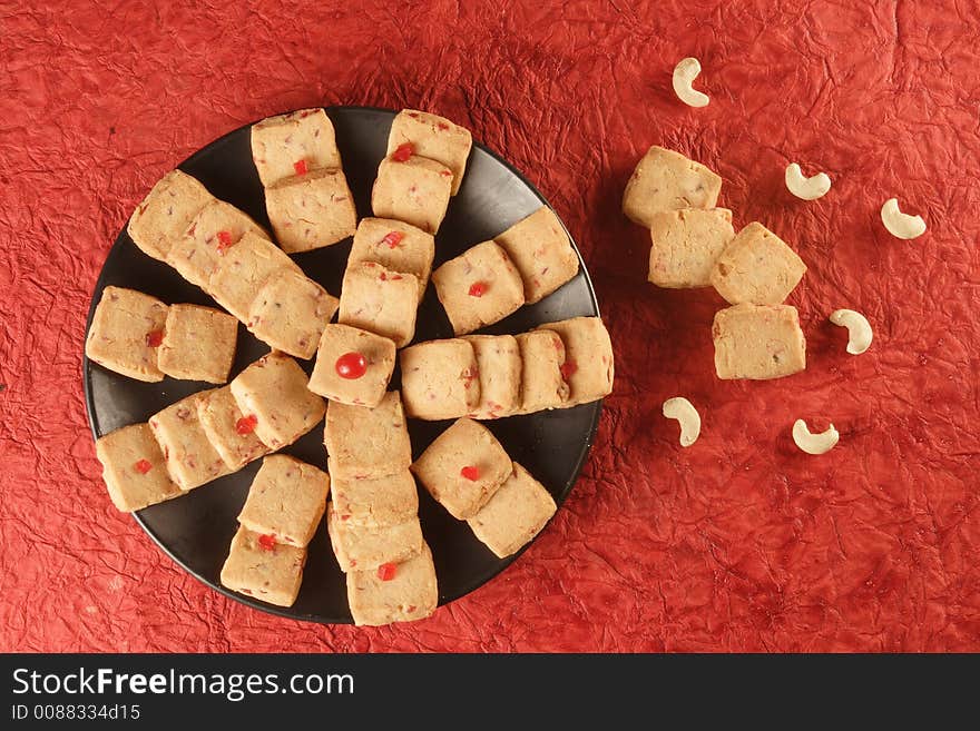 Fruit biscuits with casuenut in red background.