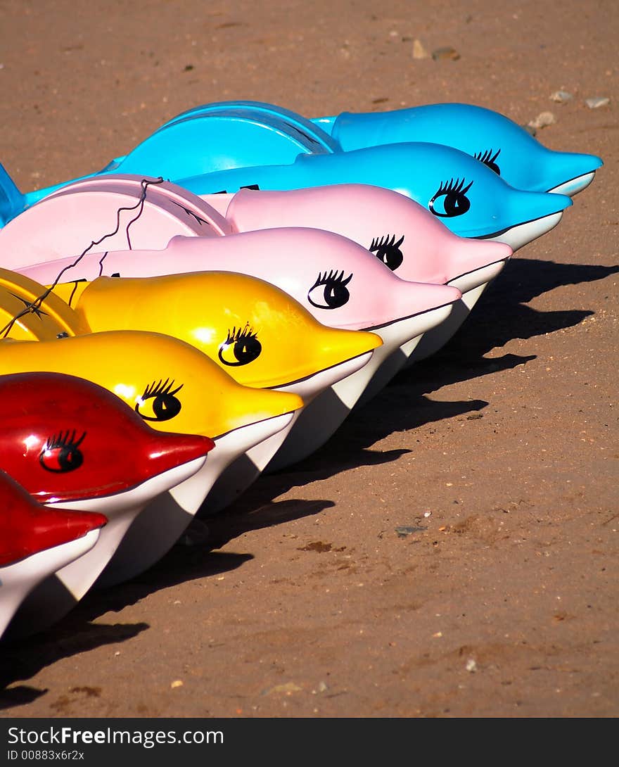 A row of plastic boats in the form of dolphins. A row of plastic boats in the form of dolphins