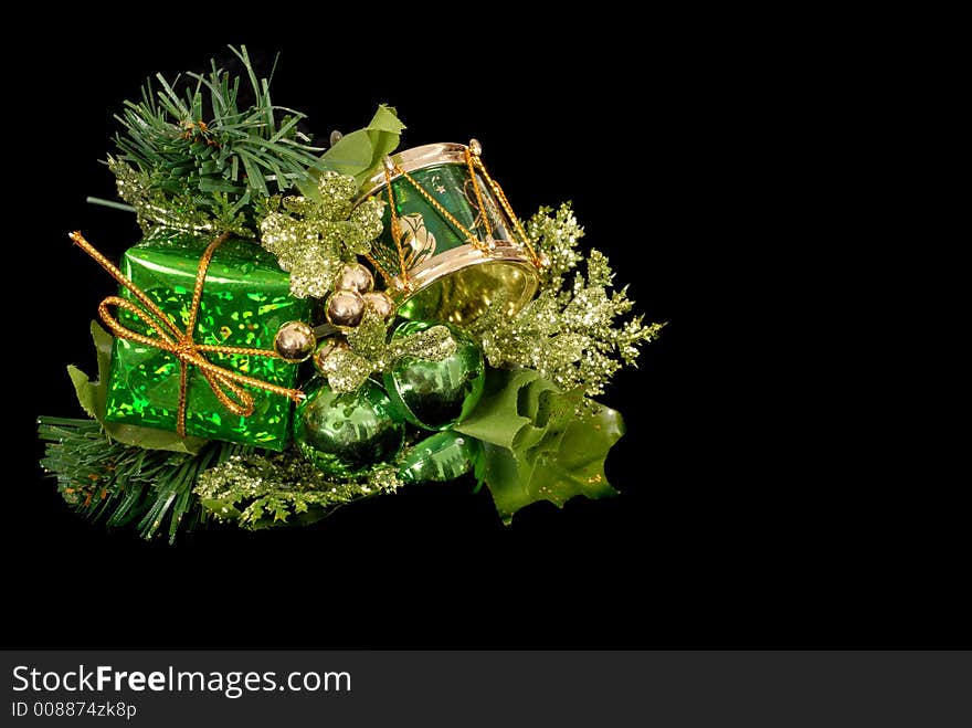 Green Christmas ornament with small wrapped package, green orbs and a small drum isolated on black. Green Christmas ornament with small wrapped package, green orbs and a small drum isolated on black