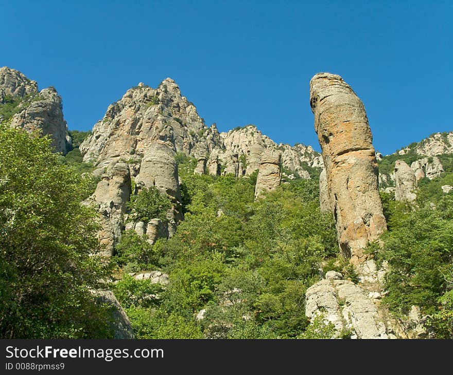 Stony figure and bushes in mountains