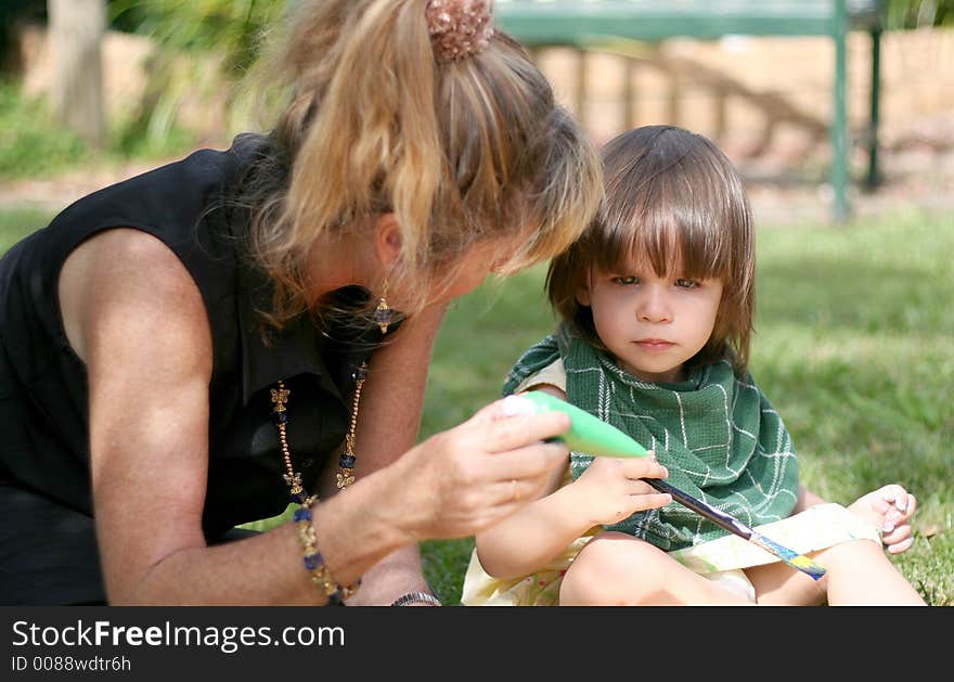 Woman painting with toddler outside. Woman painting with toddler outside