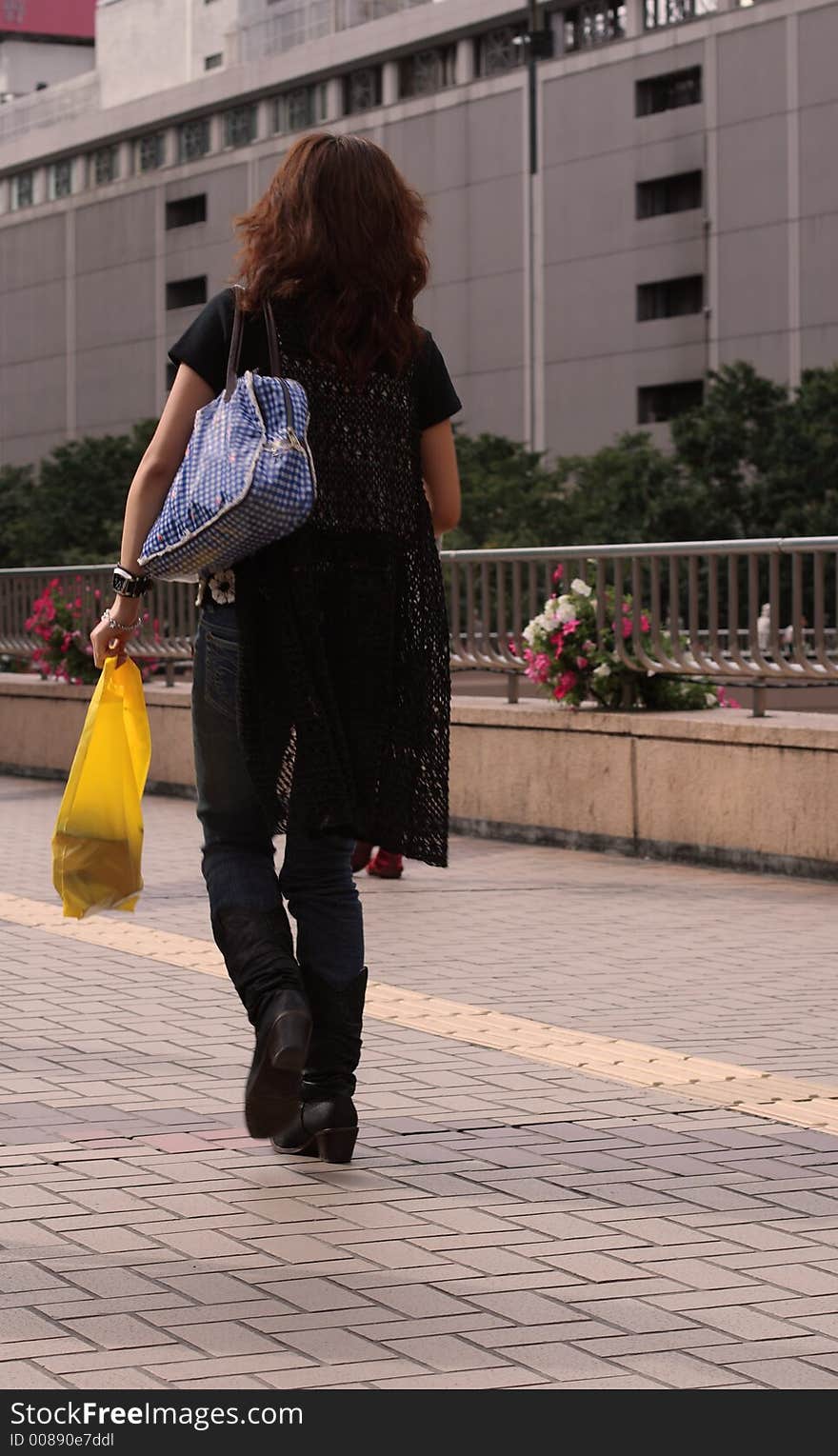 Woman walking a a shopping area of a city. Browse my Shopping collection.