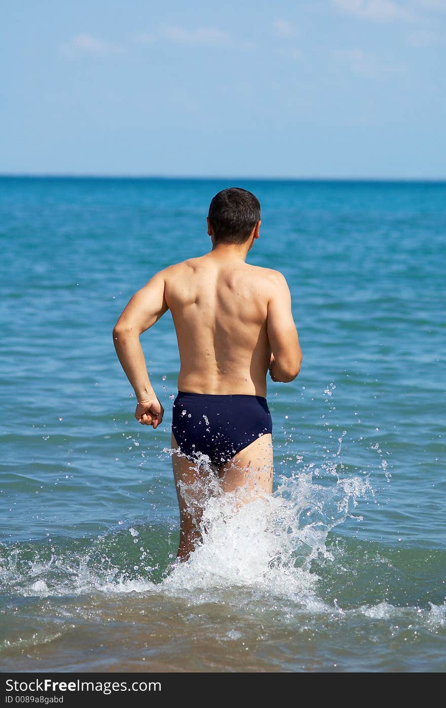 Man enters water on the beach. Man enters water on the beach