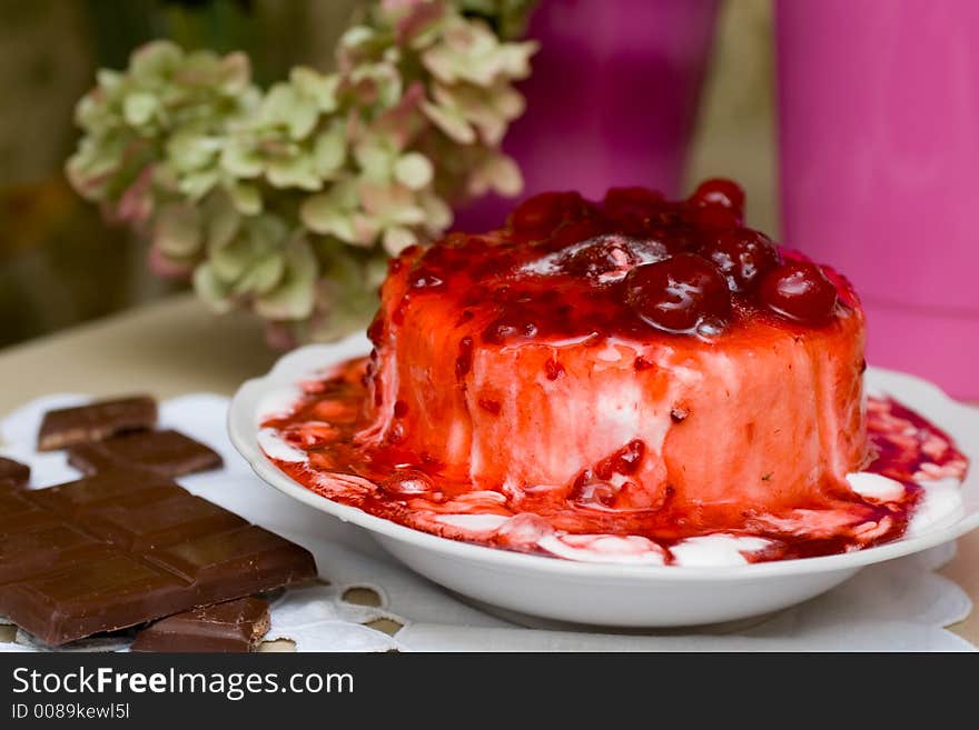 Ice-cream pudding poured with sweet cherry jam, with chocolate bar. Ice-cream pudding poured with sweet cherry jam, with chocolate bar.