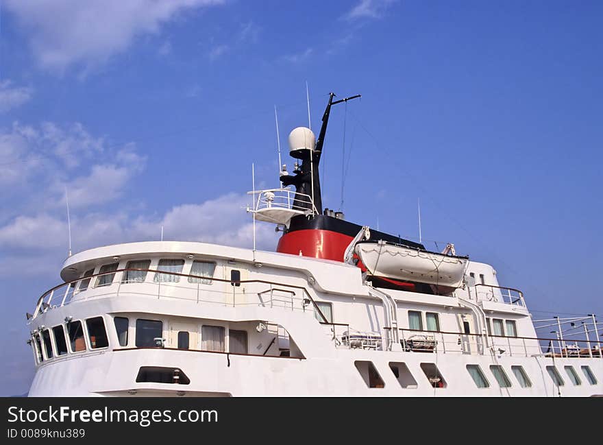 Top of a cruise ship showing command tower, funnel, radar and lifeboat. Top of a cruise ship showing command tower, funnel, radar and lifeboat