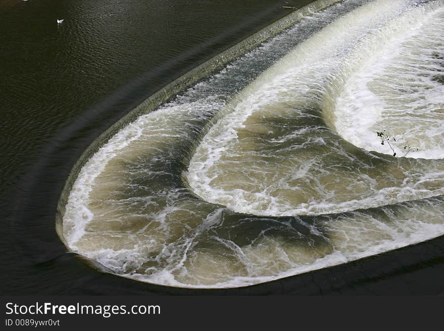 Curved Weir in bath with water flowing fast down river. Curved Weir in bath with water flowing fast down river