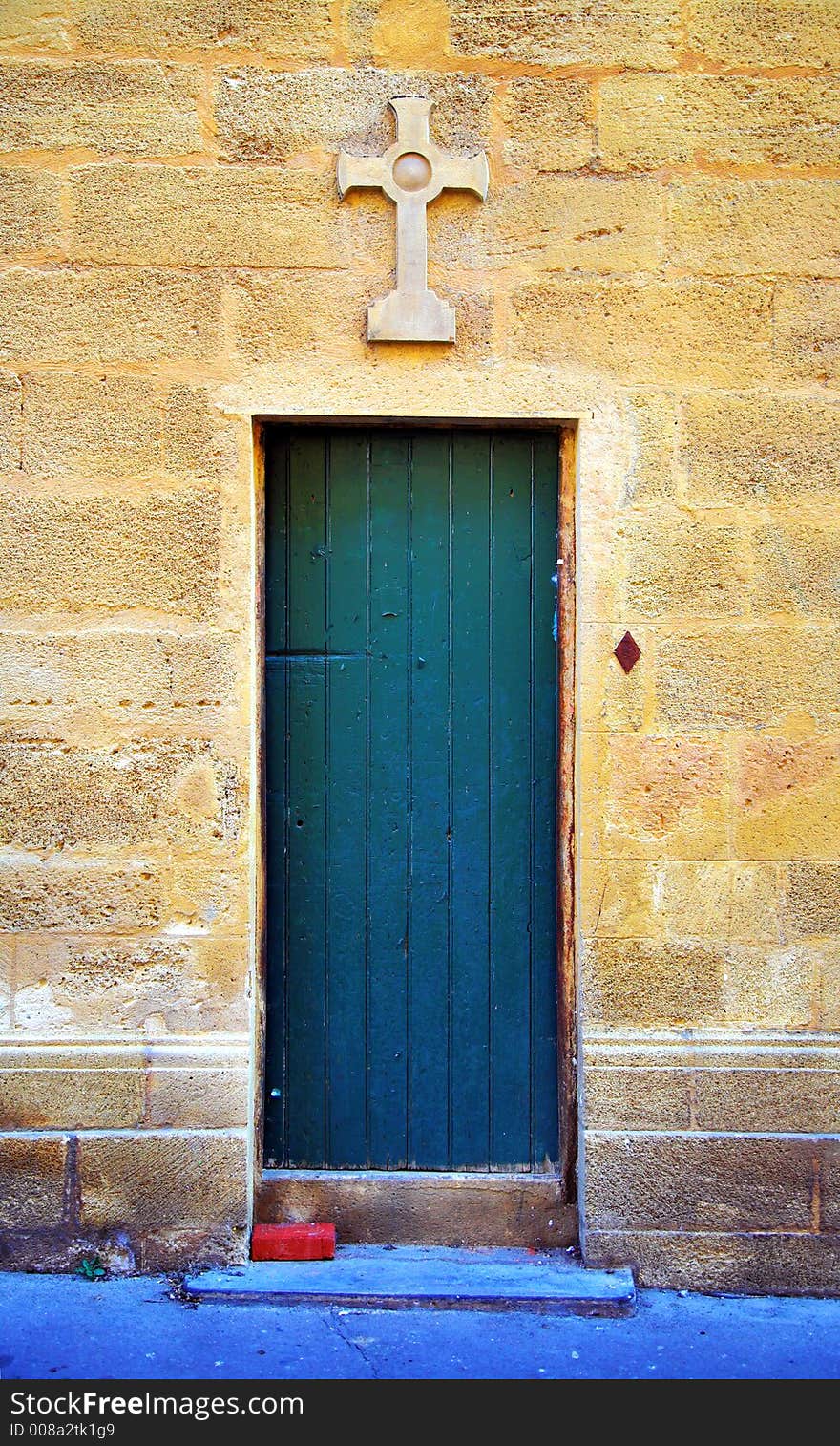 Old door on the side of a chapel in adorned with a stone cross in Aix-en-Provance, France. Old door on the side of a chapel in adorned with a stone cross in Aix-en-Provance, France