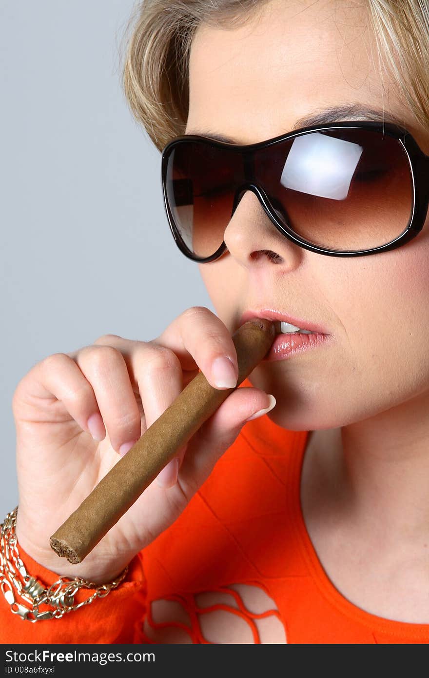 Blond woman smoking a cigar with sunglasses