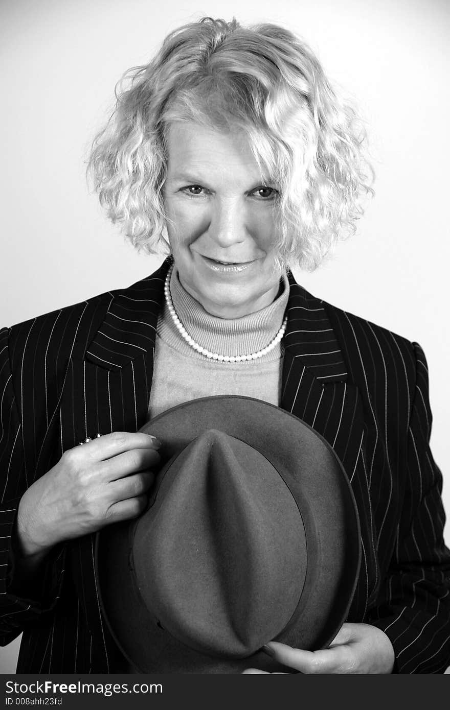 Portrait of an attractive middle-aged woman holding a hat in black & white. Portrait of an attractive middle-aged woman holding a hat in black & white.