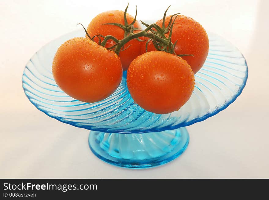 Fresh tomatoes with rain drops in a blue dish. Fresh tomatoes with rain drops in a blue dish