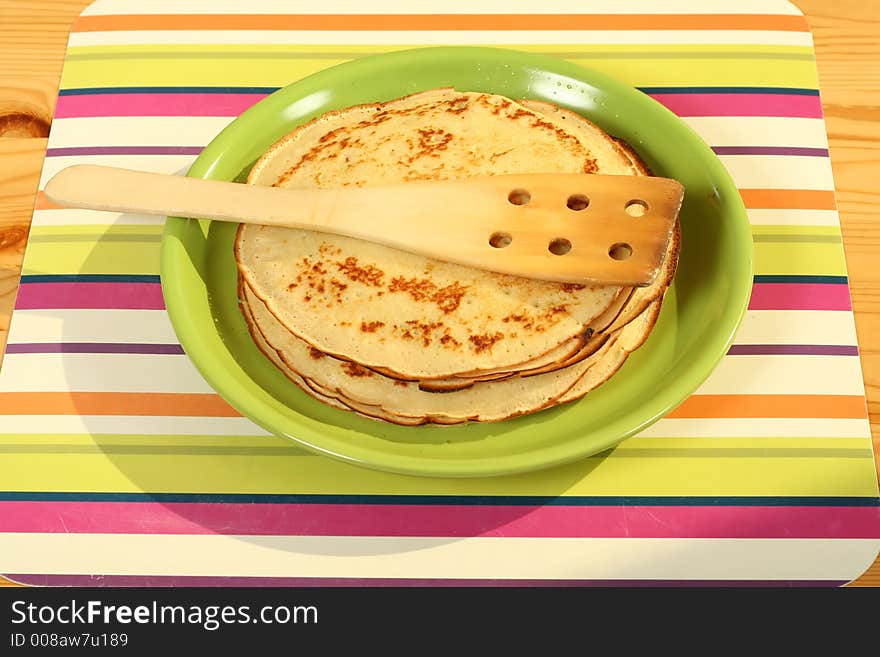 Fresh pancakes on a green plate