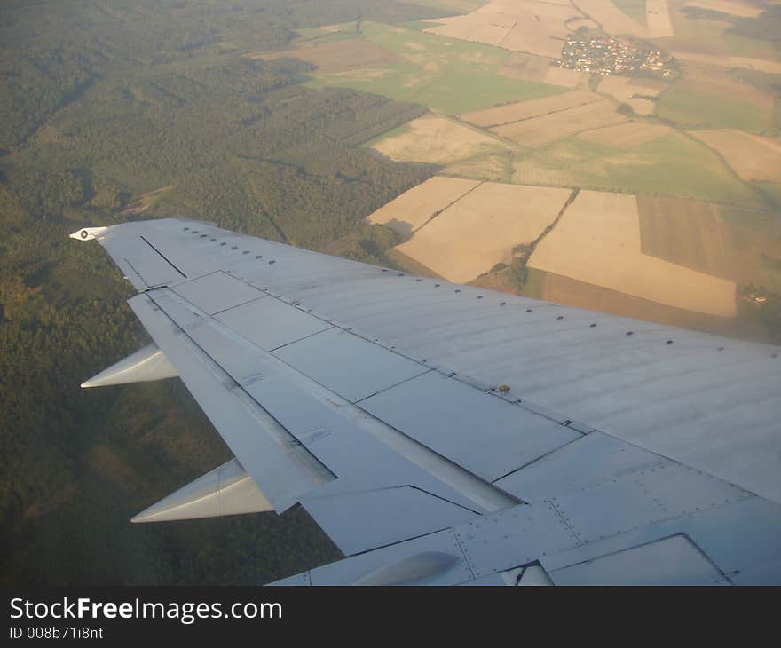 View from plane over the wing to landscape underneath. View from plane over the wing to landscape underneath.