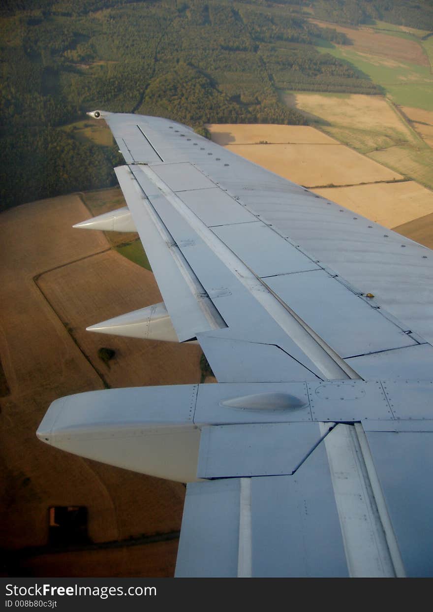 View from plane over the wing to landscape underneath. View from plane over the wing to landscape underneath.