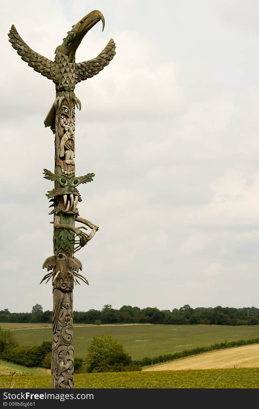 Carved wooden totem pole in green fields