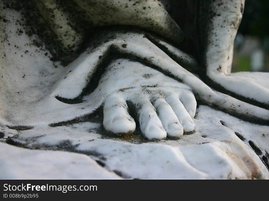 Stone foot of an angel sculpture in a cemetary