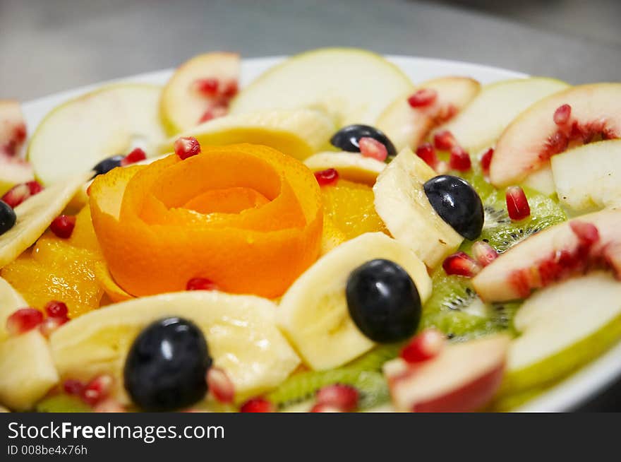 Fresh juicy fruit salad on a plate.