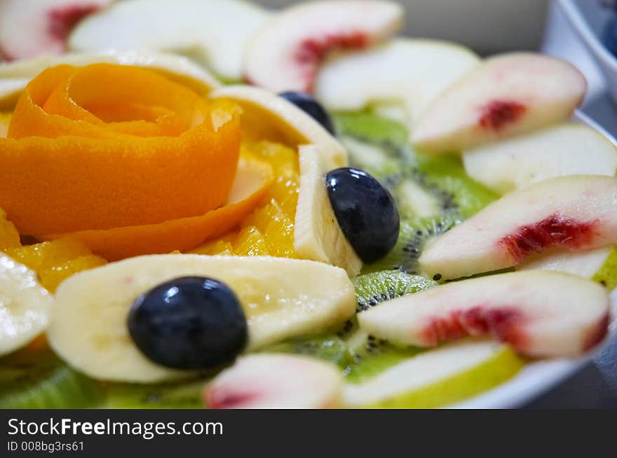 Fresh juicy fruit salad on a plate.