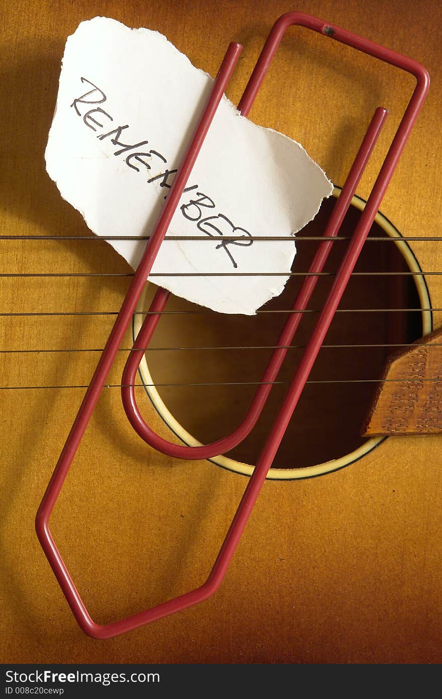 Note and paperclip on a guitar. Note and paperclip on a guitar