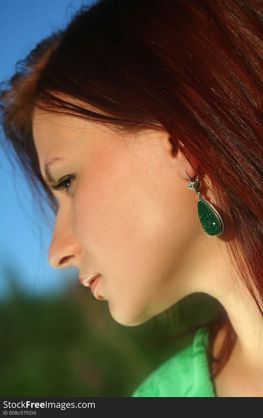 The woman with jeweller ornaments over blew sky background