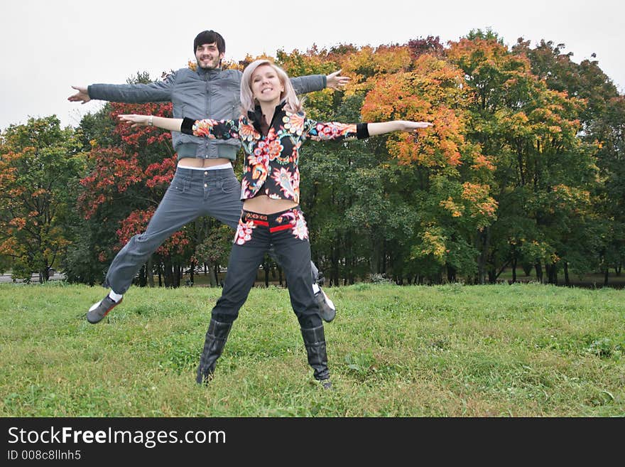 Autumn couple jump in park