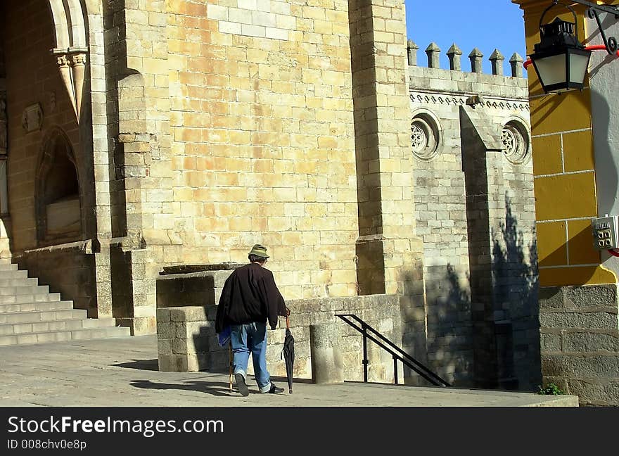 Old man passing together to the church of the Sé, Évora, Portugal. Old man passing together to the church of the Sé, Évora, Portugal