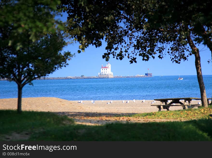 Scene with picnic area and beach in foreground and Fairport Harbor Lighthouse in the background. Scene with picnic area and beach in foreground and Fairport Harbor Lighthouse in the background