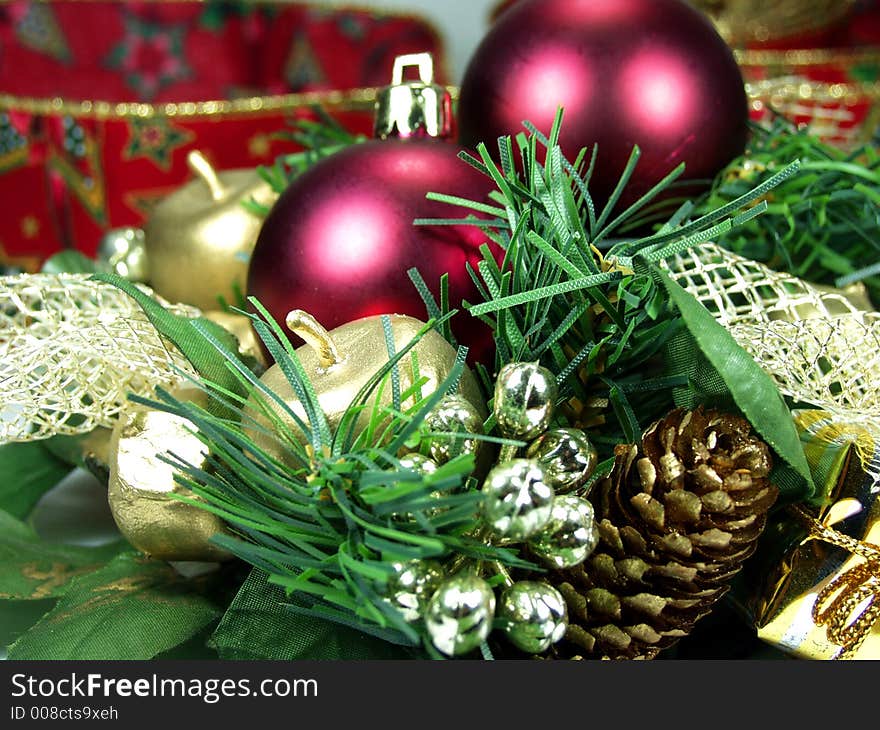 Christmas ornament made of small drum, wrapped package, gold balls and pine