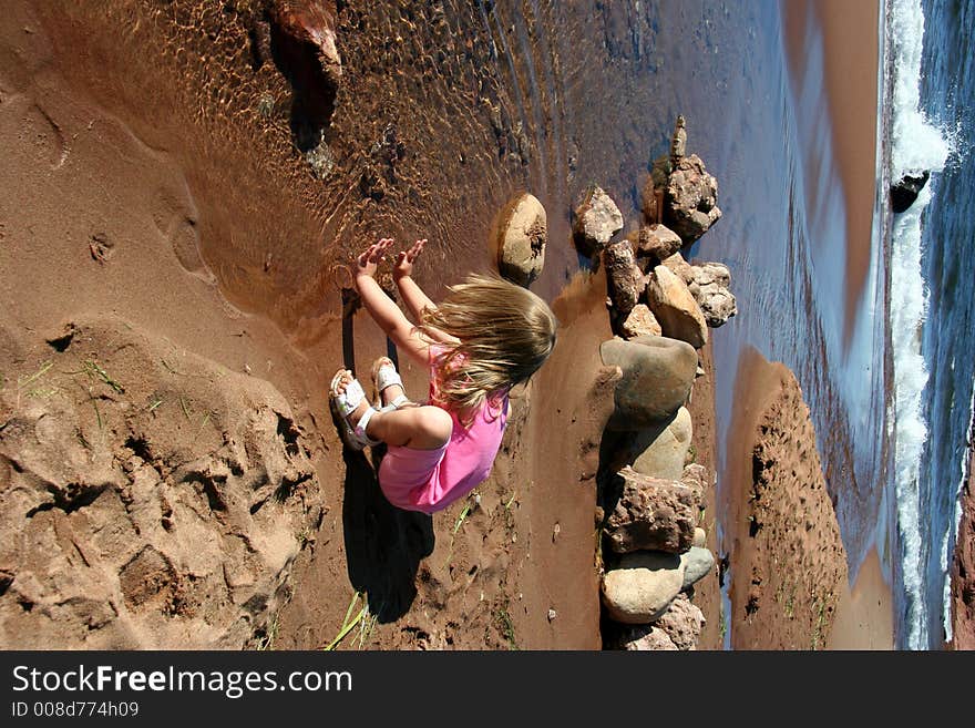 A little girl splashes on the shoreline. A little girl splashes on the shoreline