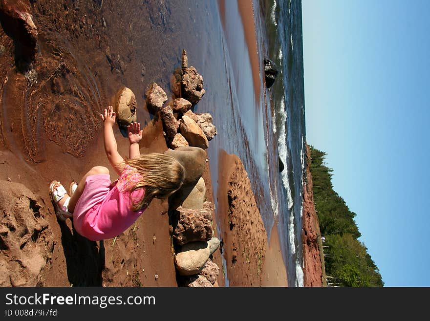 A little girl splashes on the shoreline. A little girl splashes on the shoreline