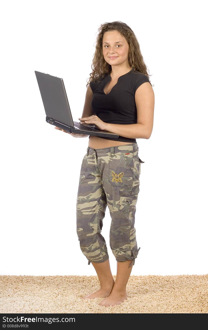 Isolated on white female teenager standing on the carpet with laptop