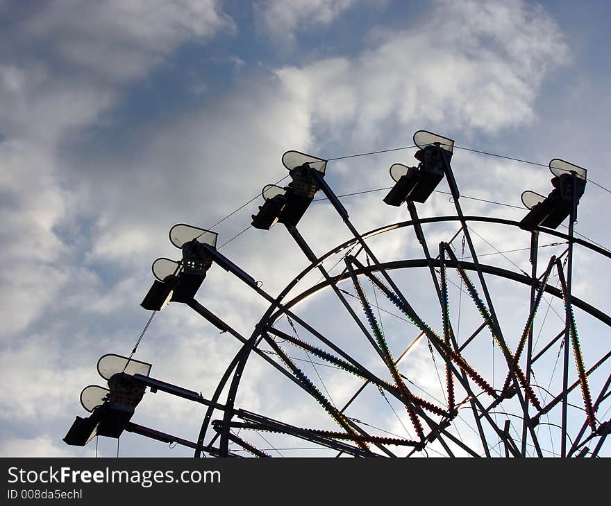 A ferris wheel against an early evening sky. A ferris wheel against an early evening sky.