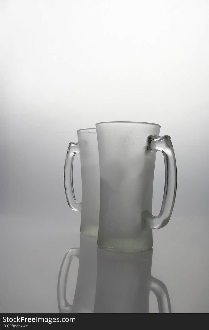 Two frozen beer mugs on a table. Two frozen beer mugs on a table