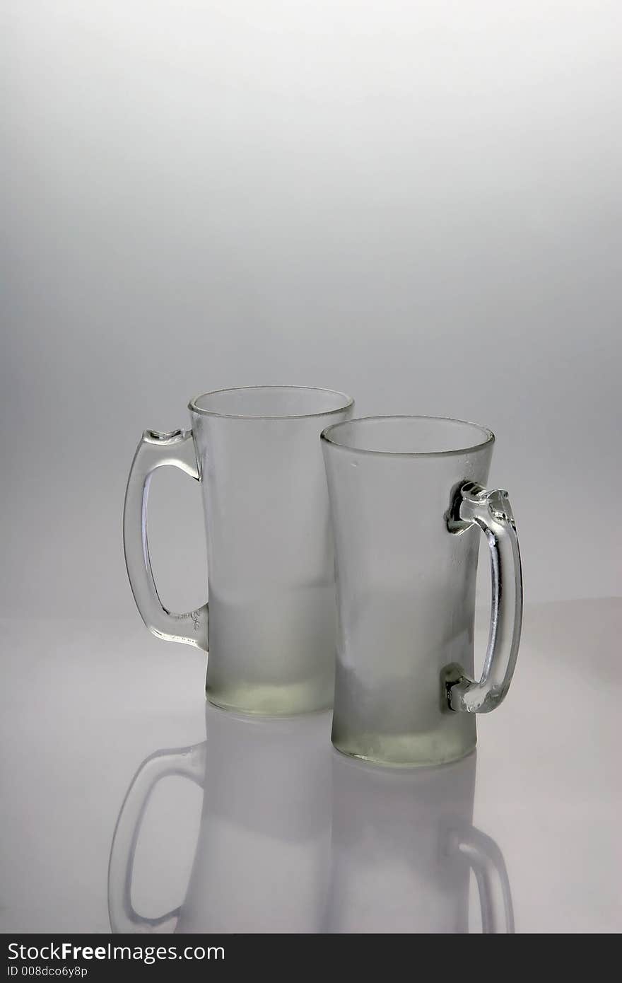 Two frozen beer mugs on a table. Two frozen beer mugs on a table