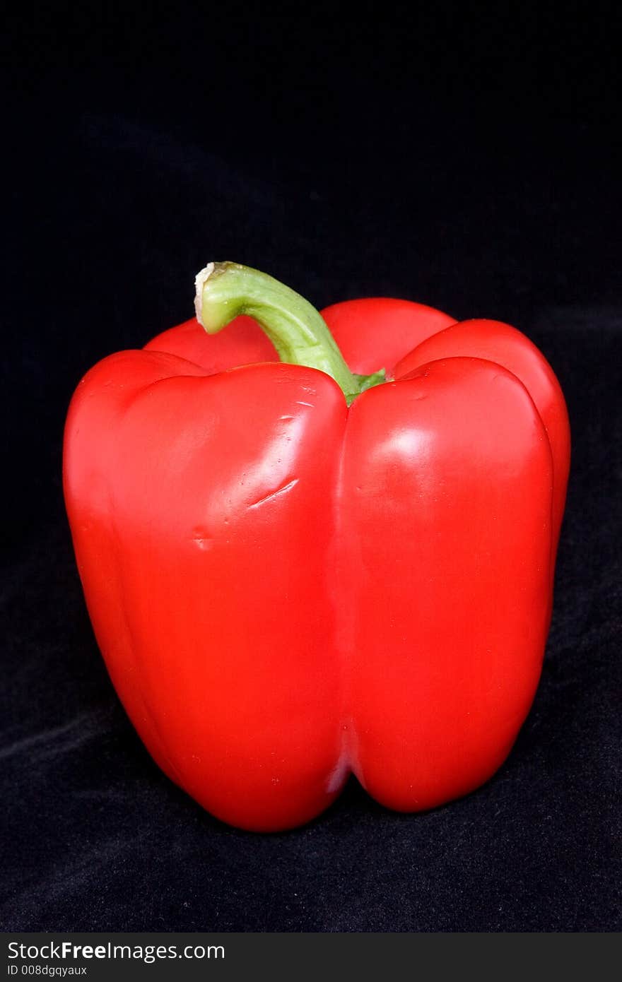 Red bell pepper on a black velvet background.