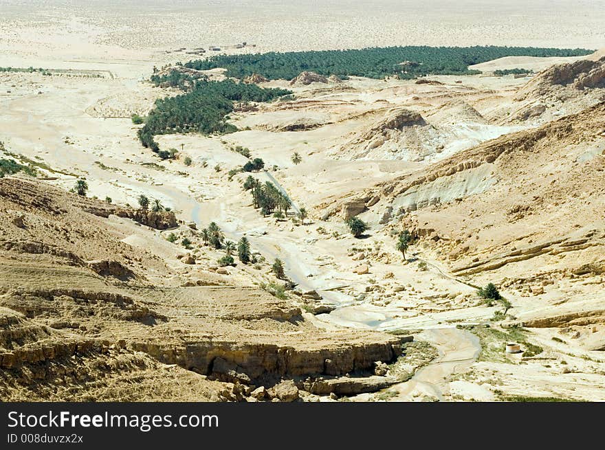 Stunning wide landscape of canyon with the river and oasis below, Tunisia. Stunning wide landscape of canyon with the river and oasis below, Tunisia