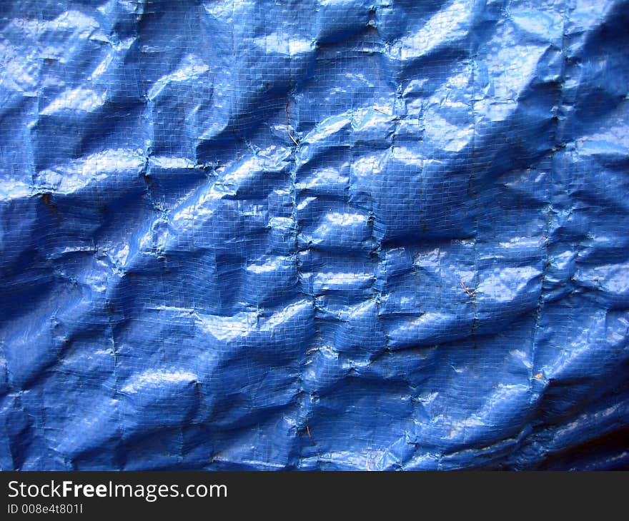 Wrinkled blue tarpaulin makes a complex background