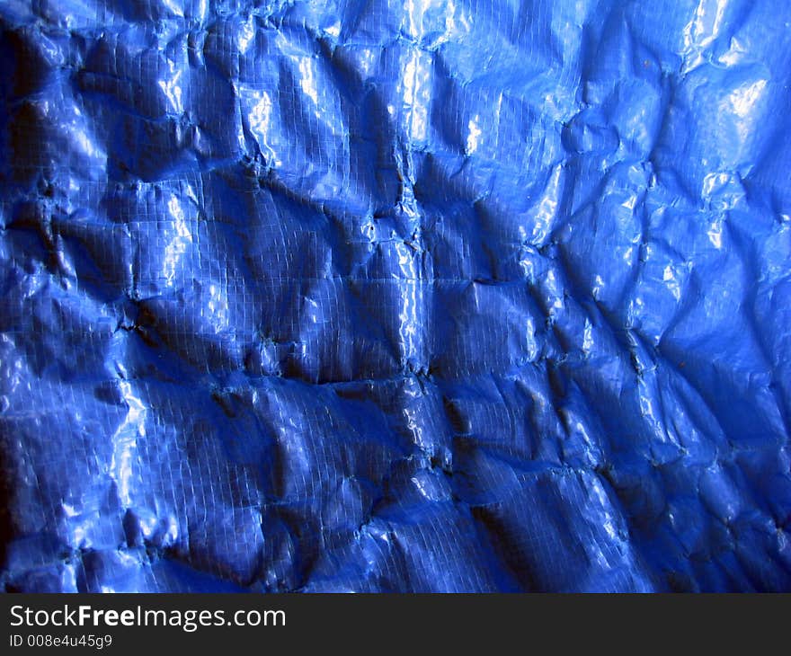 Wrinkled blue tarpaulin makes a complex background