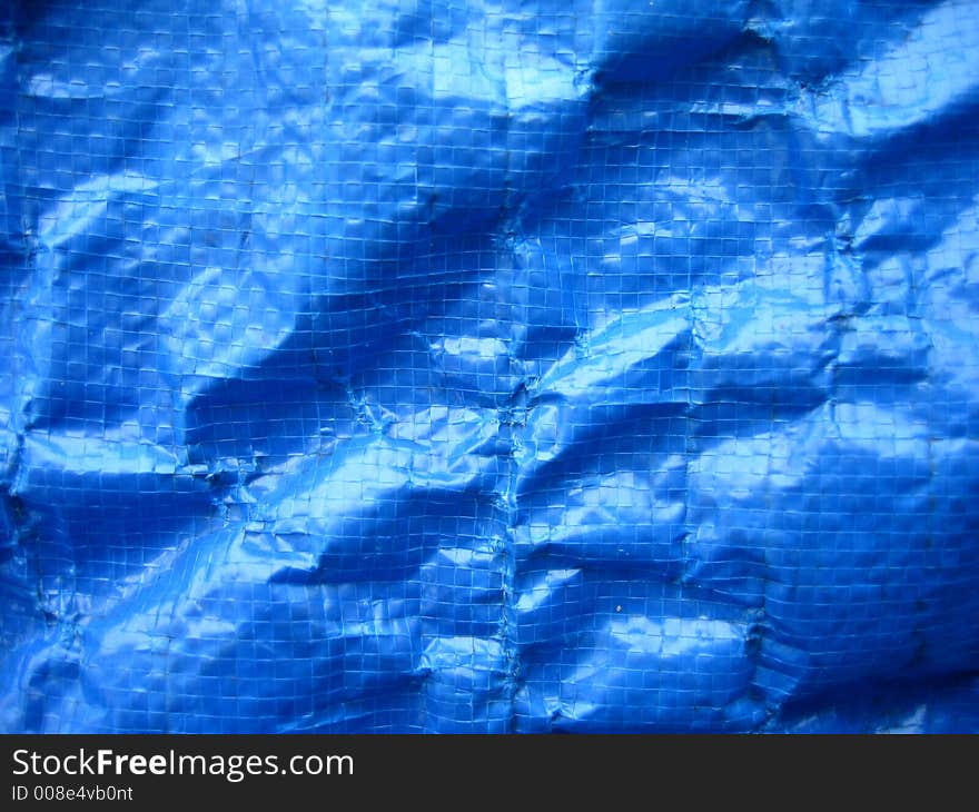 Wrinkled blue tarpaulin makes a complex background