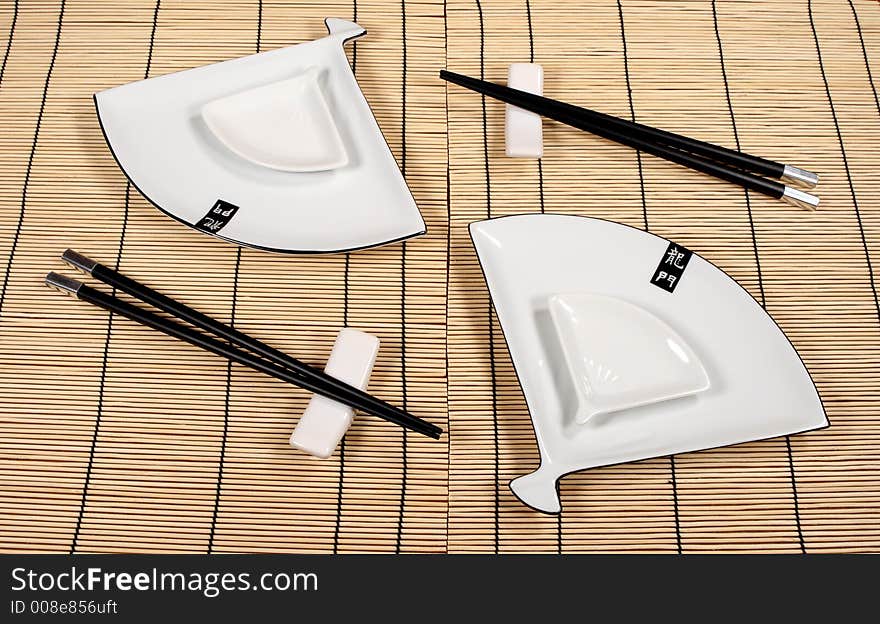 Sushi plates and chopsticks on bamboo mat. Sushi plates and chopsticks on bamboo mat