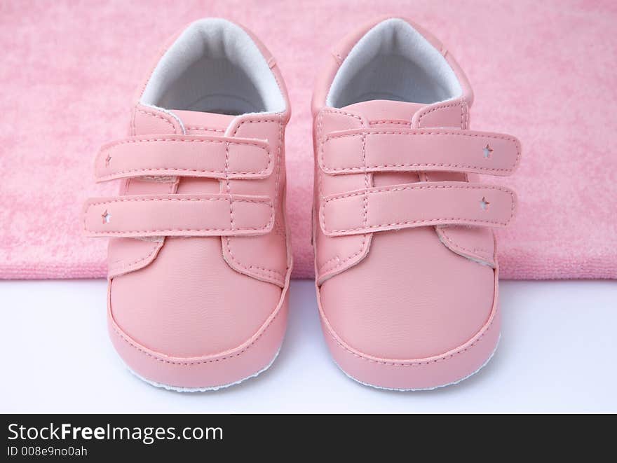 Pink baby shoes on pink towel. Pink baby shoes on pink towel