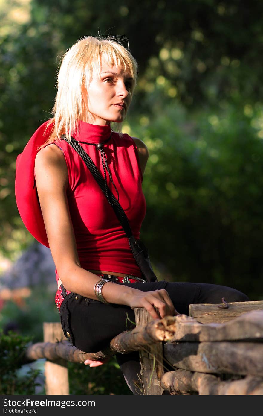 Beautiful sexy blonde cowgirl in the countryside with red hat