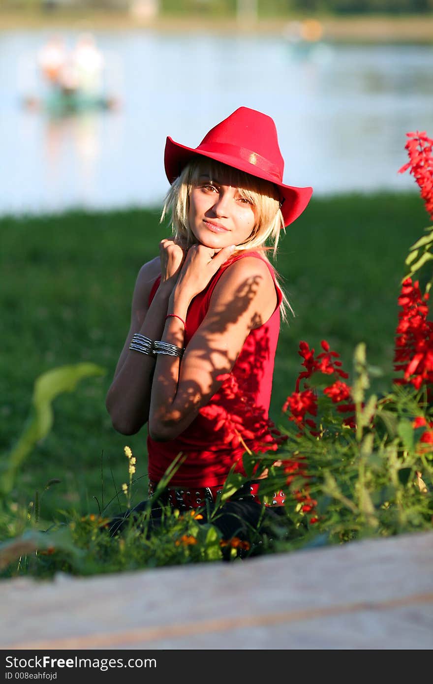 Beautiful blonde cowgirl in the countryside with red hat. Beautiful blonde cowgirl in the countryside with red hat