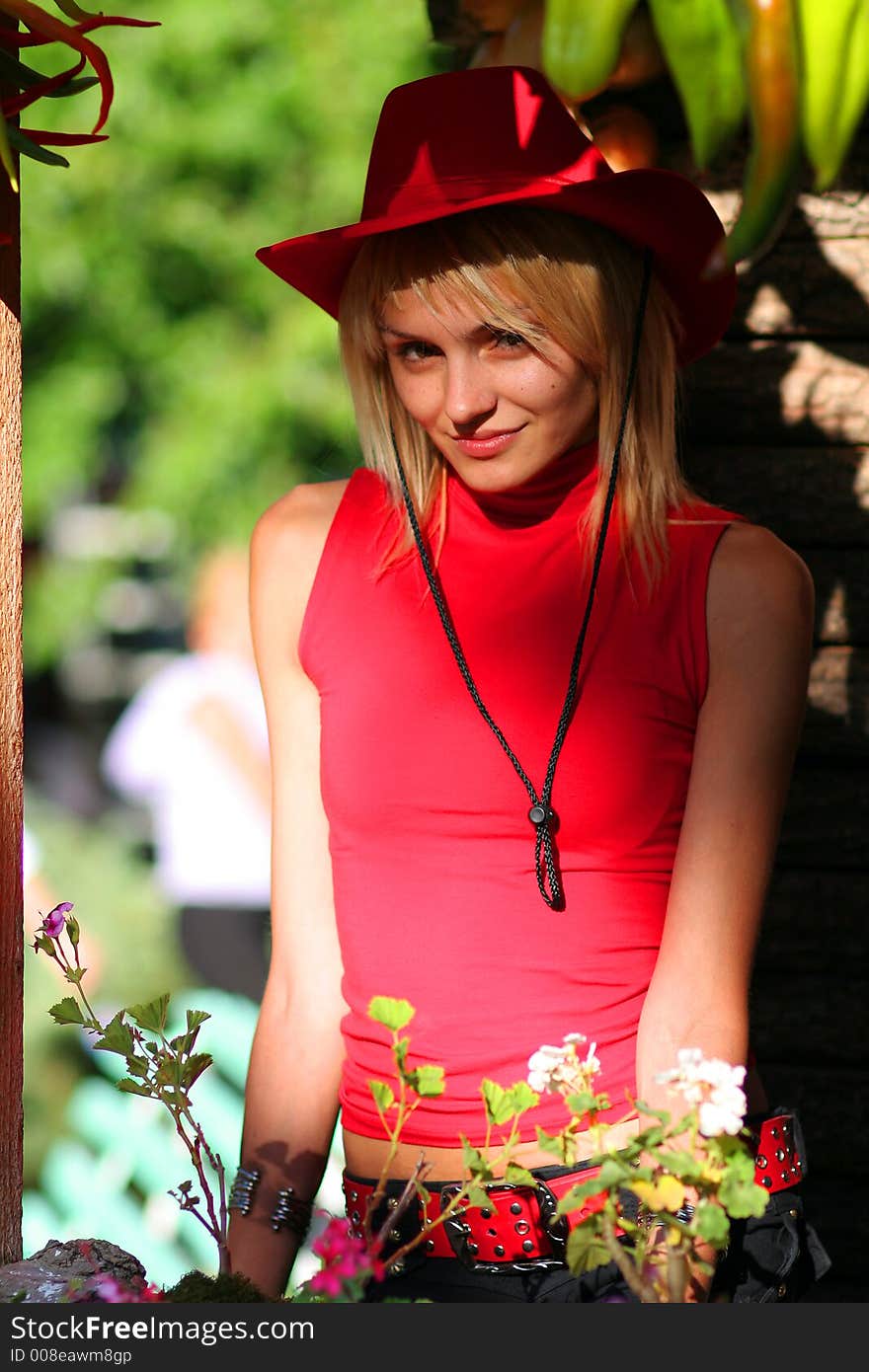 Beautiful sexy blonde cowgirl in the countryside with red hat