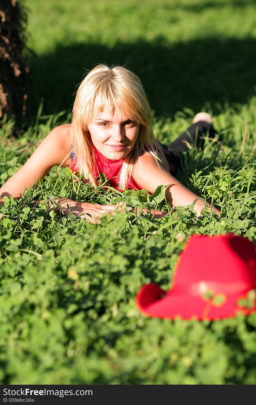 Beautiful sexy blonde cowgirl in the countryside with red hat