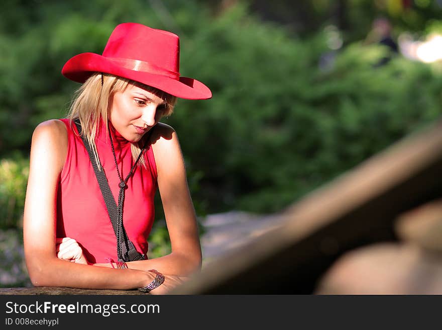 Beautiful sexy blonde cowgirl in the countryside with red hat