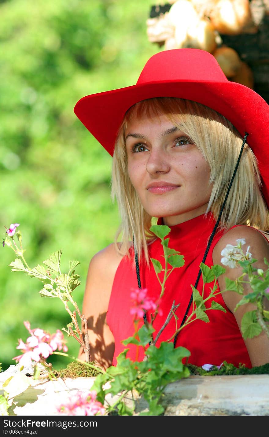 Beautiful sexy blonde cowgirl in the countryside with red hat