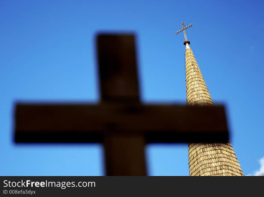 Church tower behind out of focus cross silhouette