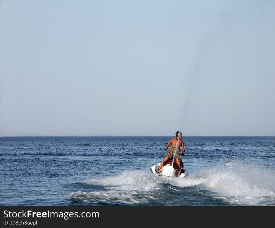 Young guy riding a jet ski. Young guy riding a jet ski